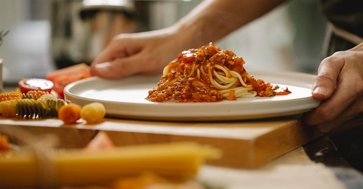 A question about browning meat for spaghetti bolognese - Cook taking plate with pasta Bolognese in kitchen A question about browning meat for spaghetti bolognese - Cook taking plate with pasta Bolognese in kitchen