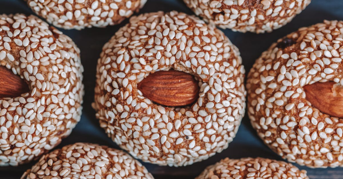 Adding raw chia seeds to baked goods? - Top view of background representing tasty biscuits with whole almonds in center and sesame seeds on top Adding raw chia seeds to baked goods? - Top view of background representing tasty biscuits with whole almonds in center and sesame seeds on top