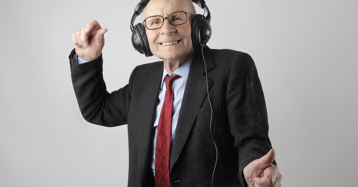 Aged steaks cooked as medium but came out looking well done - Cheerful elderly man listening to music in headphones Aged steaks cooked as medium but came out looking well done - Cheerful elderly man listening to music in headphones