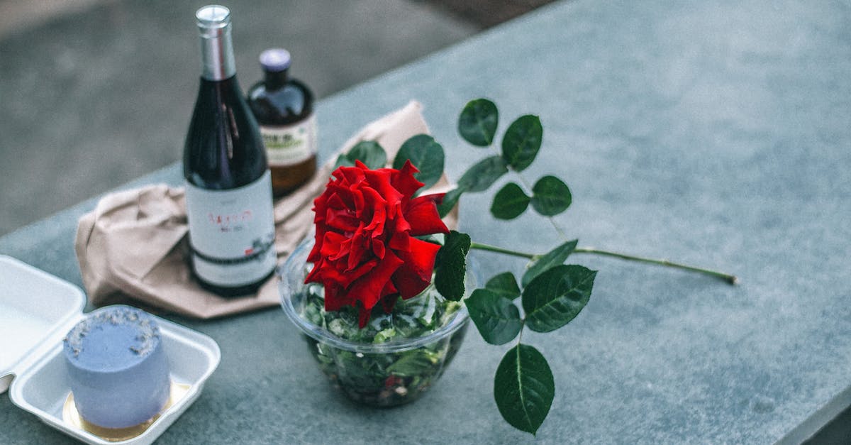 Alcohol-optional desserts? - Composition of red rose placed on parapet near champagne bottle Alcohol-optional desserts? - Composition of red rose placed on parapet near champagne bottle