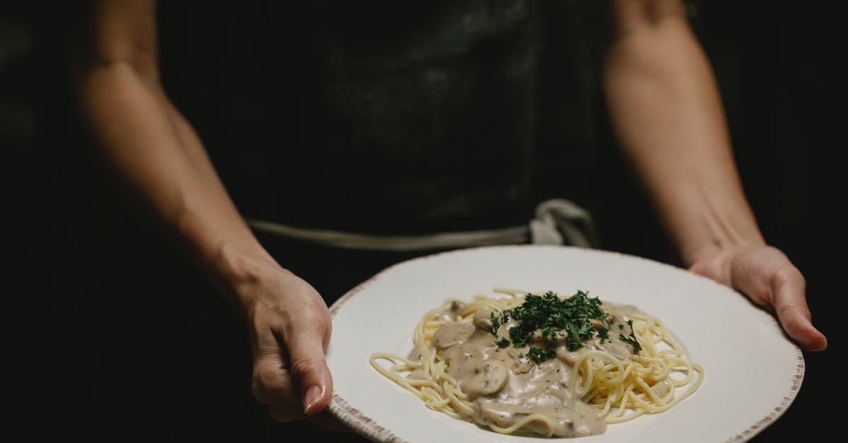 Alfredo sauce - help adding taste - Person with plate of pasta with mushrooms Alfredo sauce - help adding taste - Person with plate of pasta with mushrooms