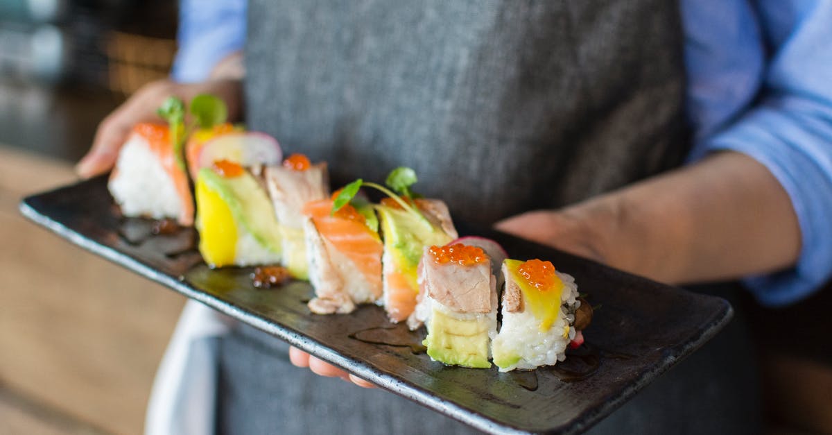 Am I cooking frozen fish safely? - Person Holding Sushi on Black Plate Am I cooking frozen fish safely? - Person Holding Sushi on Black Plate