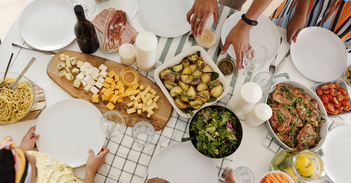 American Potatoes vs. Spanish Potatoes - People around a Table With Food American Potatoes vs. Spanish Potatoes - People around a Table With Food