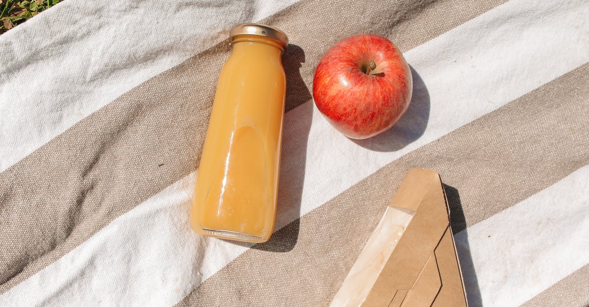 Apple Pie in a Jar Drink - Close-Up Shot of a Glass Jar of Drink beside an Apple