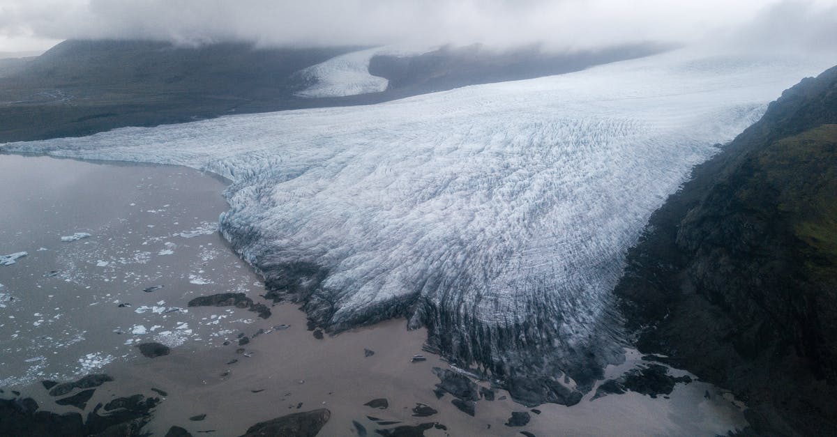 Arctic char available in North-America - Majestic glacier tongue reaching seashore under gloomy misty sky Arctic char available in North-America - Majestic glacier tongue reaching seashore under gloomy misty sky