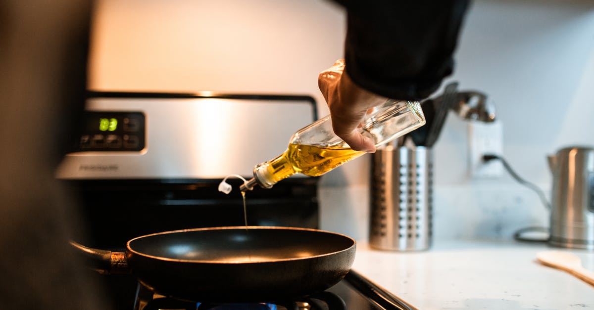 Are chilies in olive oil dangerous? - Back view crop unrecognizable person pouring olive or sunflower oil into frying pan placed on stove in domestic kitchen Are chilies in olive oil dangerous? - Back view crop unrecognizable person pouring olive or sunflower oil into frying pan placed on stove in domestic kitchen
