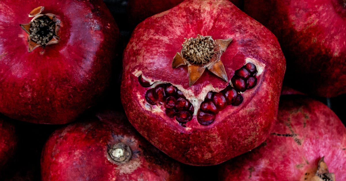 Are edible skins of supermarket fruits safe to eat, or are residues a problem? - Top view of fresh ripe pomegranates stacked on table in local food market Are edible skins of supermarket fruits safe to eat, or are residues a problem? - Top view of fresh ripe pomegranates stacked on table in local food market