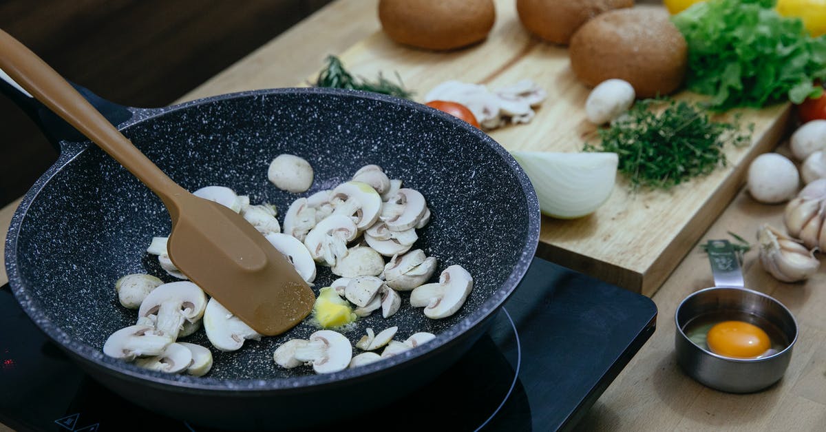 Are garlic butter and garlic oil interchangeable? - Chopped mushrooms in frying pan placed on stove near various veggies and herbs Are garlic butter and garlic oil interchangeable? - Chopped mushrooms in frying pan placed on stove near various veggies and herbs