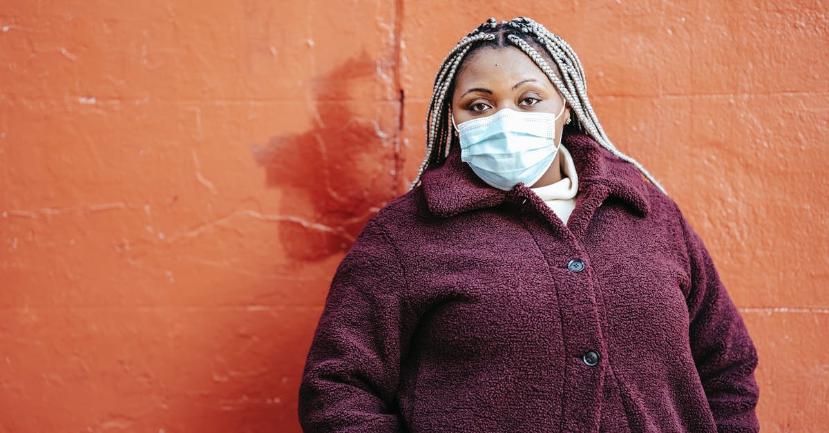 Are purple spots in freezer safe? - Pensive African American female with dreadlocks in casual clothes and protective mask standing near red painted wall on street and looking at camera Are purple spots in freezer safe? - Pensive African American female with dreadlocks in casual clothes and protective mask standing near red painted wall on street and looking at camera