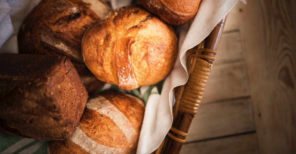 Are the bubbles in the sourdough starter caused by yeast cultures? - Fresh bread in basket placed on wooden surface