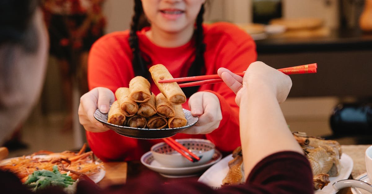 Are the bubbles in the sourdough starter caused by yeast cultures? - Crop ethnic teen serving spring rolls to relative at home