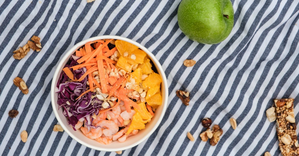 Are there culinary applications for carrot tops/greens? - Top view of fresh poke bowl near green apple and nuts on surface Are there culinary applications for carrot tops/greens? - Top view of fresh poke bowl near green apple and nuts on surface