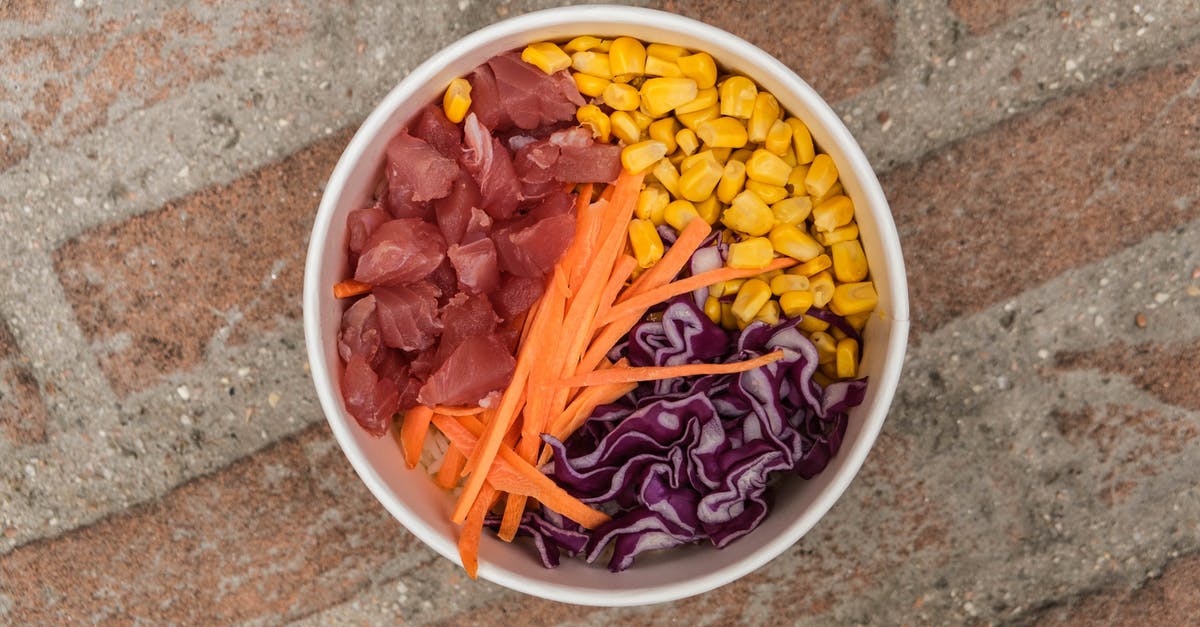 Are there culinary applications for carrot tops/greens? - Top view of bowl with carrot meat and fresh corn placed on rough brick surface Are there culinary applications for carrot tops/greens? - Top view of bowl with carrot meat and fresh corn placed on rough brick surface