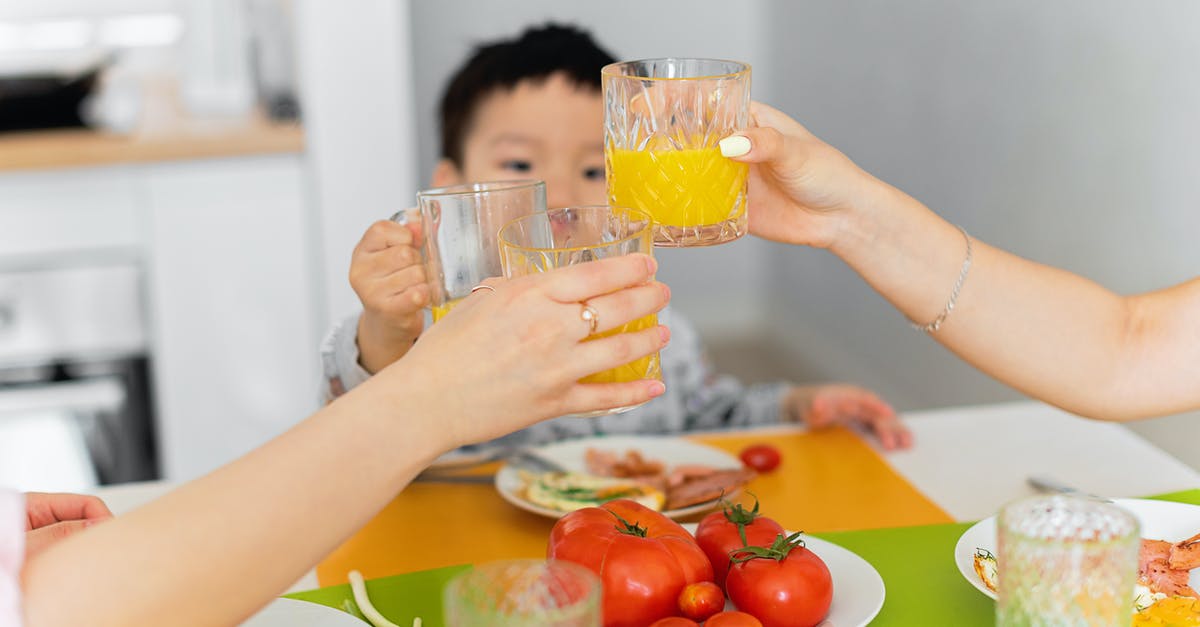 Asian toasting seeds - Two Women and Boy Toasting with Glasses of Juice During Dinner Asian toasting seeds - Two Women and Boy Toasting with Glasses of Juice During Dinner