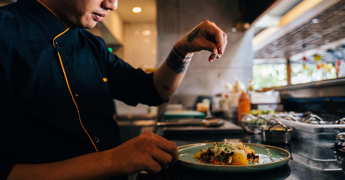 Asian toasting seeds - A Chef Sprinkling Sesame Seeds on a Salad Dish Asian toasting seeds - A Chef Sprinkling Sesame Seeds on a Salad Dish