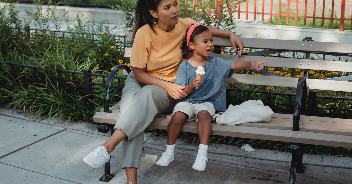 At what point (after clams die) are they ok to eat - Asian mother and kid sitting on bench on street in sunny day At what point (after clams die) are they ok to eat - Asian mother and kid sitting on bench on street in sunny day