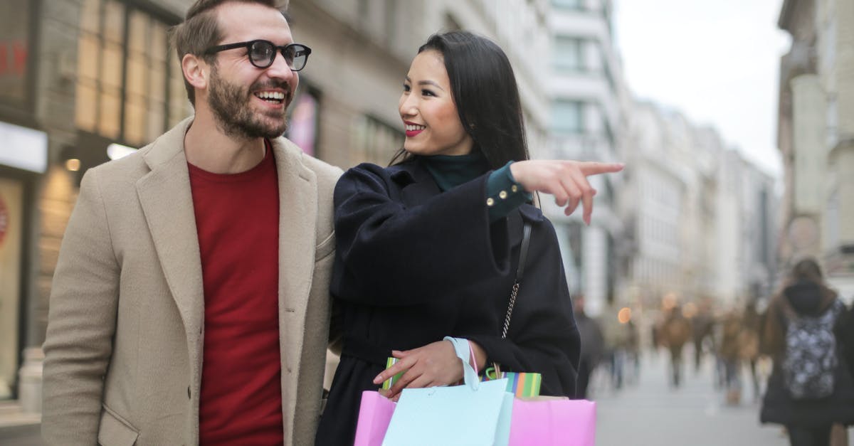 At what point should carrots be thrown away? - From below happy stylish Asian woman in warm clothes smiling at cheerful unshaven man in glasses and pointing finger away while walking along street together in city after shopping At what point should carrots be thrown away? - From below happy stylish Asian woman in warm clothes smiling at cheerful unshaven man in glasses and pointing finger away while walking along street together in city after shopping