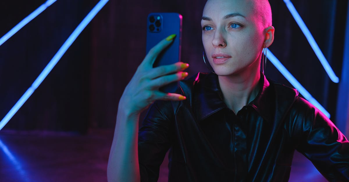Avoiding over-mixing when using a stand mixer - Young Bald woman using photos on smartphone in neon studio Avoiding over-mixing when using a stand mixer - Young Bald woman using photos on smartphone in neon studio