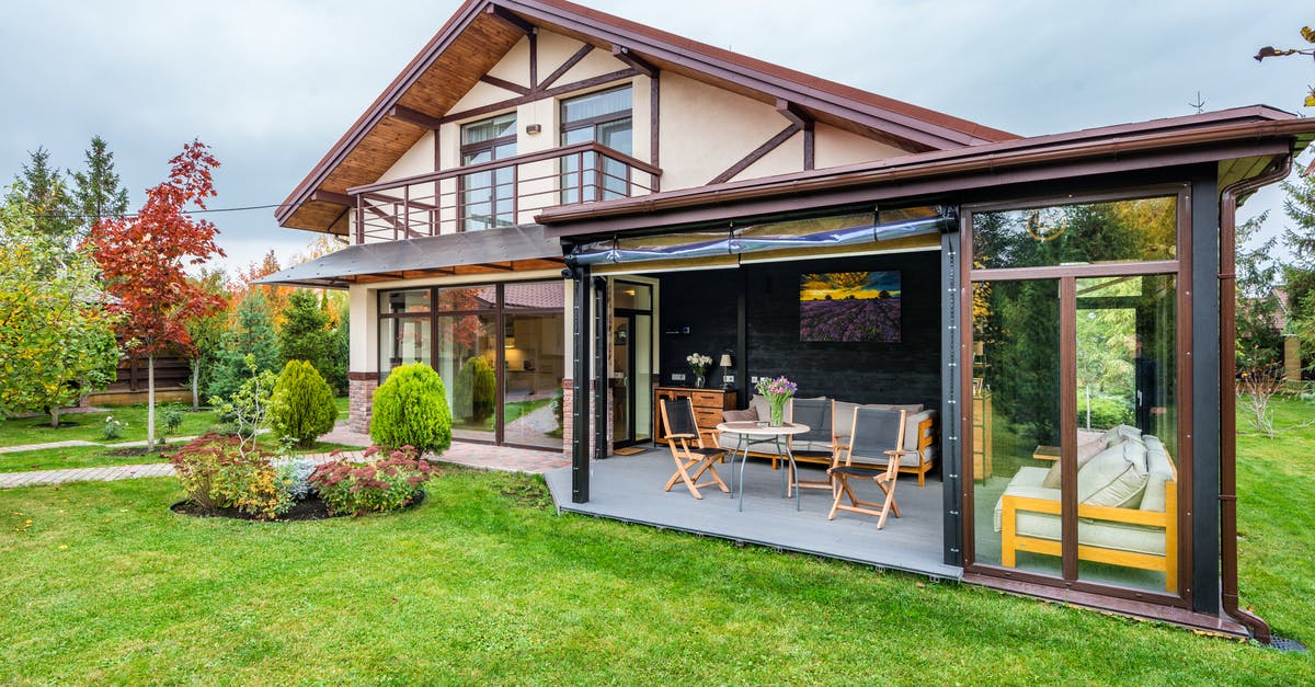 Backyard mint too grassy - Residential cottage with balcony and opened veranda opening view on lawn and trees growing in backyard Backyard mint too grassy - Residential cottage with balcony and opened veranda opening view on lawn and trees growing in backyard