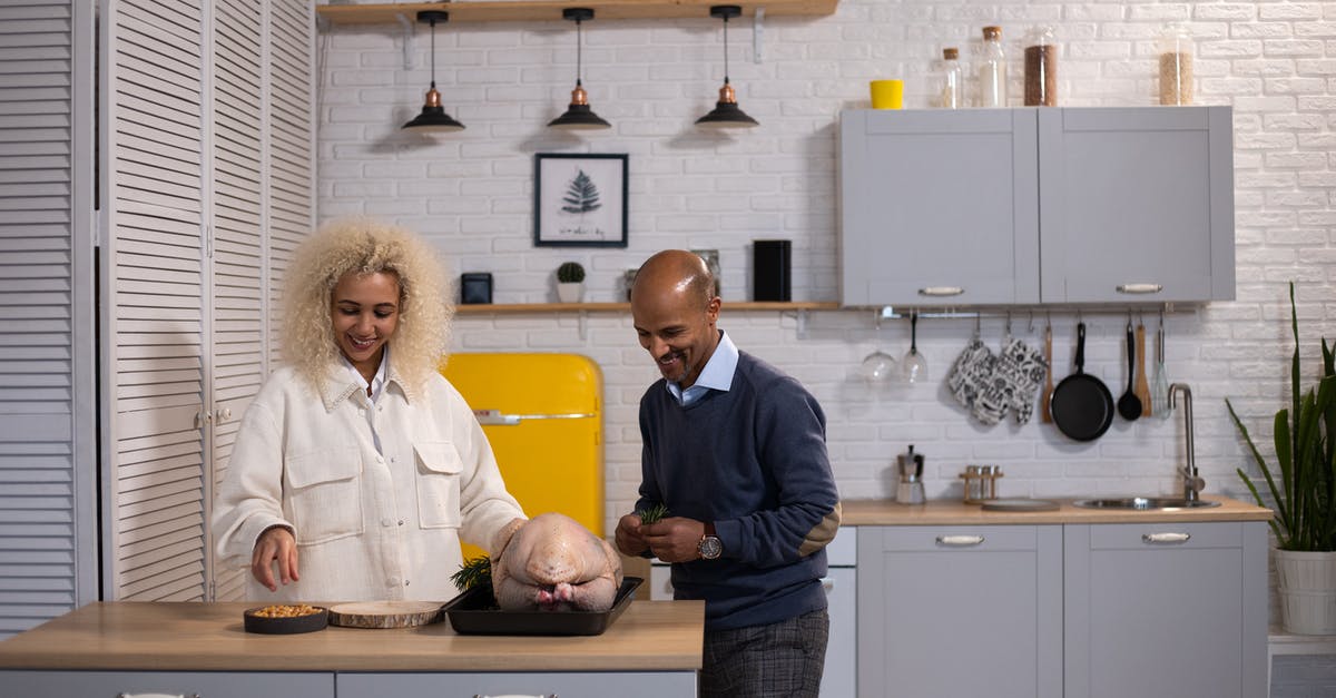 Baked Stuffing and cooking the turkey - Positive black couple preparing turkey in kitchen Baked Stuffing and cooking the turkey - Positive black couple preparing turkey in kitchen