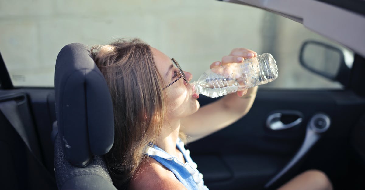 Baking in drinking glasses -- heat vs. logo paint, other issues - High angle side view of young woman in glasses and casual clothes drinking water from plastic transparent bottle while sitting in cabriolet with open roof in traffic jam in hot sunny day Baking in drinking glasses -- heat vs. logo paint, other issues - High angle side view of young woman in glasses and casual clothes drinking water from plastic transparent bottle while sitting in cabriolet with open roof in traffic jam in hot sunny day