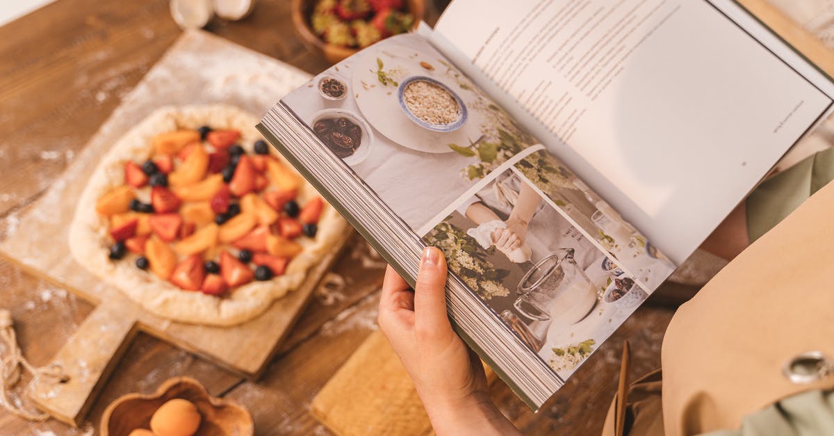 Baking side of pizza stone - Person Holding Cookbook Baking side of pizza stone - Person Holding Cookbook