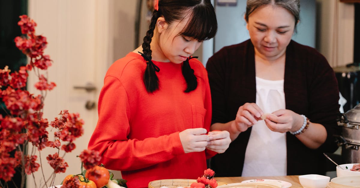 Bamboo Steamer VS Normal Steamer - Ethnic grandma with teen preparing traditional oriental dish at table with fresh vegetables and steamer in house Bamboo Steamer VS Normal Steamer - Ethnic grandma with teen preparing traditional oriental dish at table with fresh vegetables and steamer in house