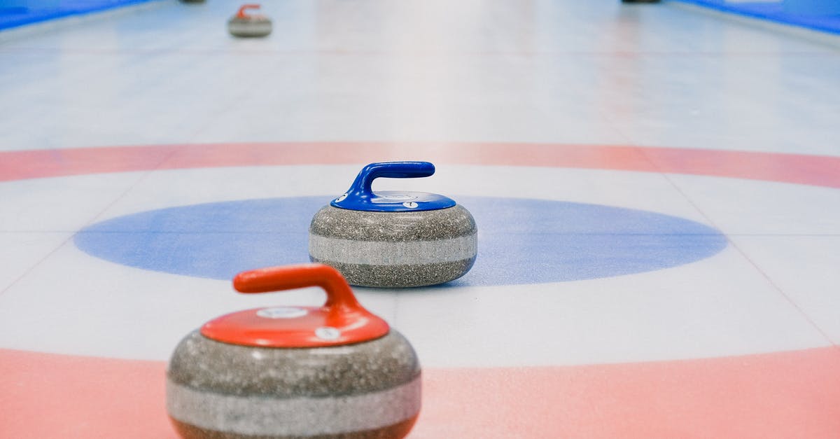 Battle Of the Gums? (effects on Ice Cream) - Red and blue handled curling stones placed on circles of house of ice arena while competition Battle Of the Gums? (effects on Ice Cream) - Red and blue handled curling stones placed on circles of house of ice arena while competition