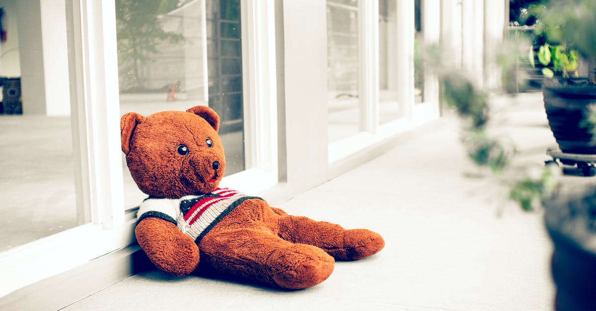 Bear in a crock pot - Toy bear on walkway against glass wall Bear in a crock pot - Toy bear on walkway against glass wall