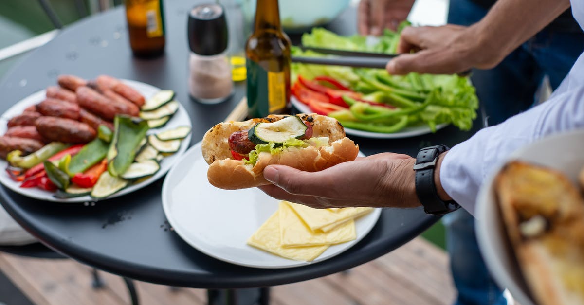 Beef breakfast sausage - Person Holding Burger With Lettuce and Tomato Beef breakfast sausage - Person Holding Burger With Lettuce and Tomato