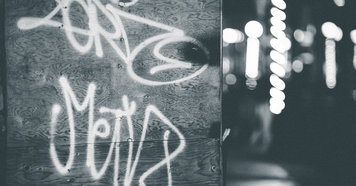 Black paint chipping of electric grill: is it still safe? - Black and white vandal graffiti on wall against bright shining lamps of street Black paint chipping of electric grill: is it still safe? - Black and white vandal graffiti on wall against bright shining lamps of street