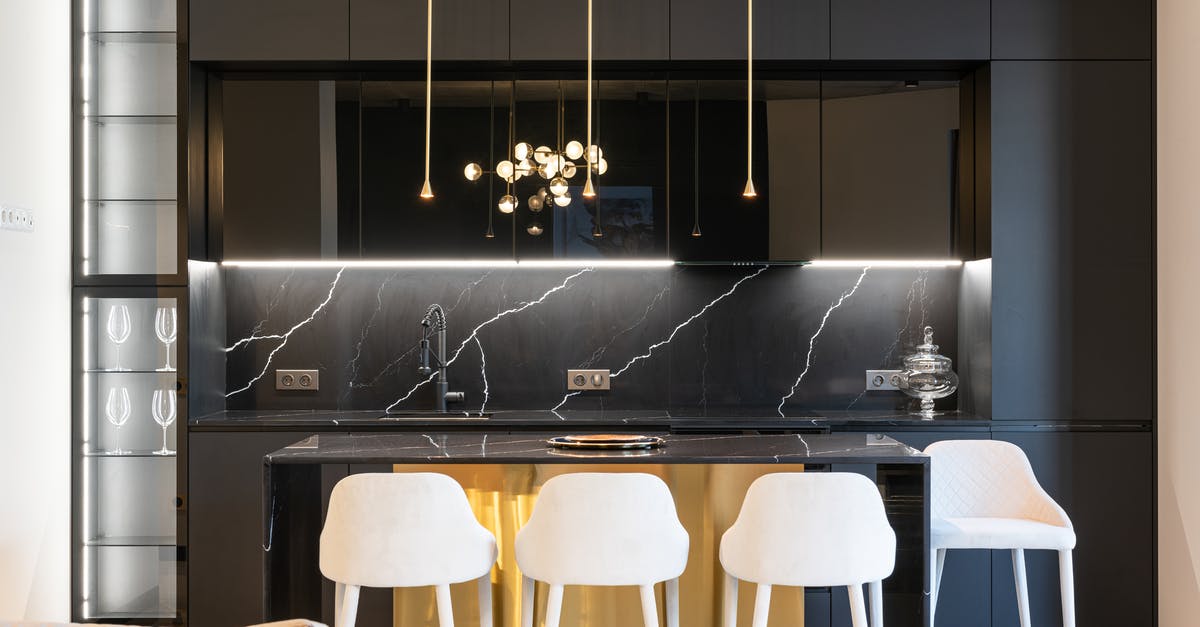 Black spots in the kitchen sink - Kitchen interior with counter near chairs and cabinets Black spots in the kitchen sink - Kitchen interior with counter near chairs and cabinets