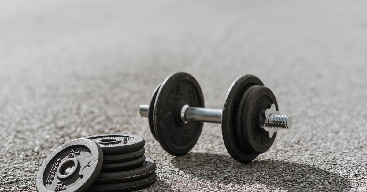 Black spotting/dust in stainless steel utensils.Is this mildew? - Dumbbell near pile of plates on pavement in sunlight Black spotting/dust in stainless steel utensils.Is this mildew? - Dumbbell near pile of plates on pavement in sunlight