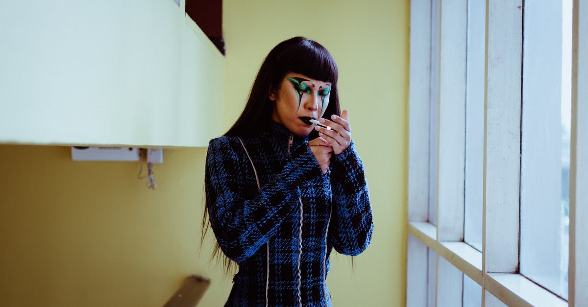 Blue Cheese has gone bad? - Stylish Asian woman with body art on face cigarette near window Blue Cheese has gone bad? - Stylish Asian woman with body art on face cigarette near window