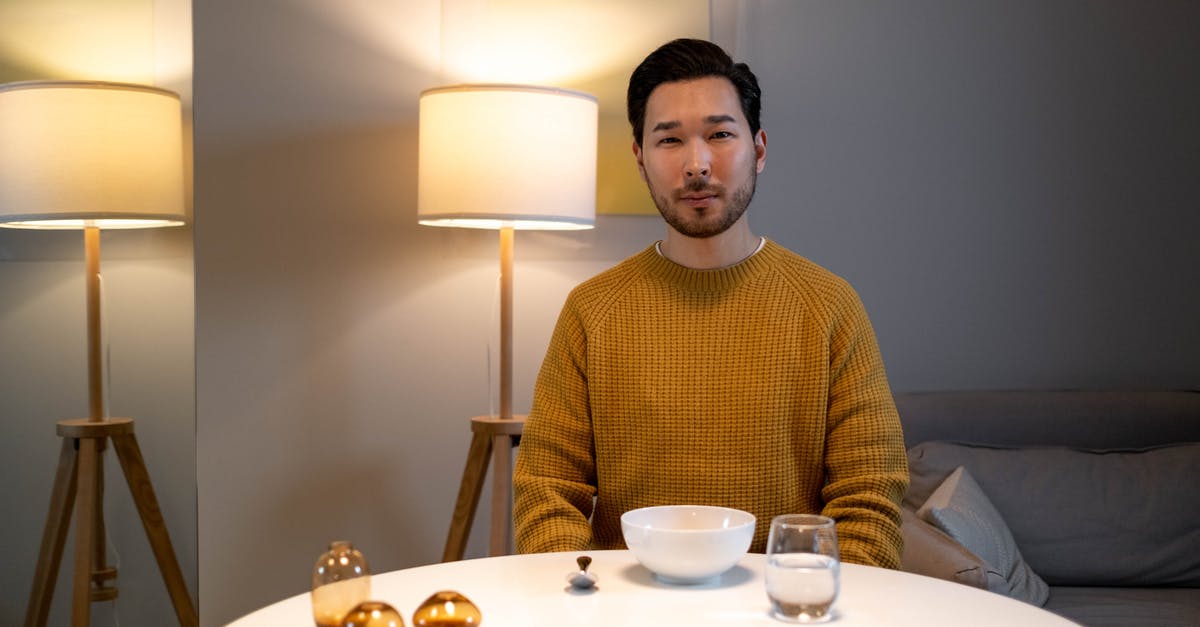 Boiled Ribs left in water overnight, parents say its fine to eat [duplicate] - Man in Brown Sweater Sitting by the Table with a Bowl and Glass of Water