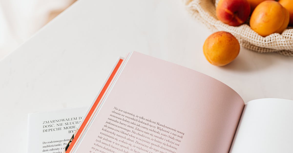 Books for very high level vegan cooking? - From above of opened book placed on white table near cotton sack with natural ripe apricots