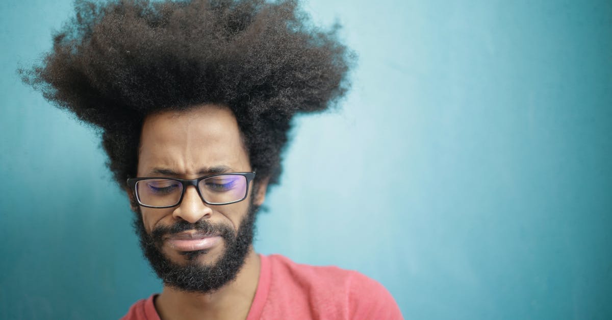 Boudin Balls, Isaac Toups - Question about cooling/refrigerating the boudin - Young bearded ethnic male with creative Afro hairstyle wearing eyeglasses and pink t shirt looking down pensively thinking about trouble or question