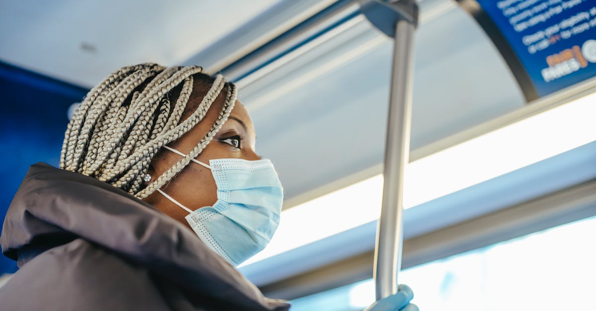 Braided bread: how to prevent ropes from springing back - From below side view of African American female medic in disposable glove and mask looking forward in public vehicle Braided bread: how to prevent ropes from springing back - From below side view of African American female medic in disposable glove and mask looking forward in public vehicle