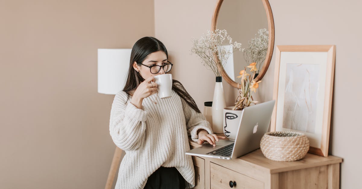 Brewing coffee concentrate using both hot and cold methods - Freezing concentrate - Busy female using laptop and drinking hot beverage at home Brewing coffee concentrate using both hot and cold methods - Freezing concentrate - Busy female using laptop and drinking hot beverage at home