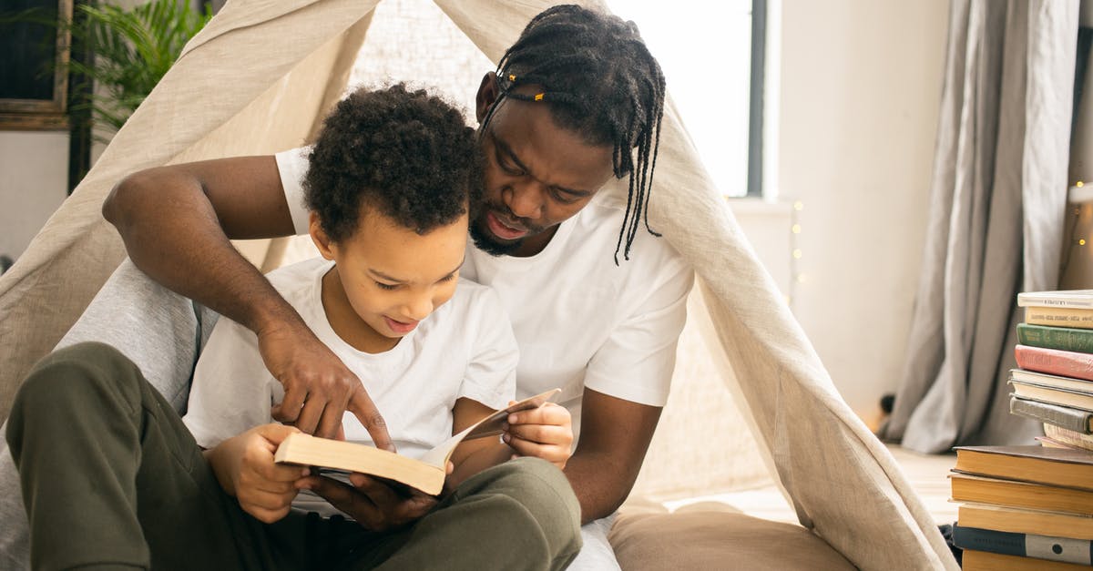 Brisket: separating the flat from the point prior to smoking - Focused African American dad sitting and reading book with positive sun un living room in daytime Brisket: separating the flat from the point prior to smoking - Focused African American dad sitting and reading book with positive sun un living room in daytime