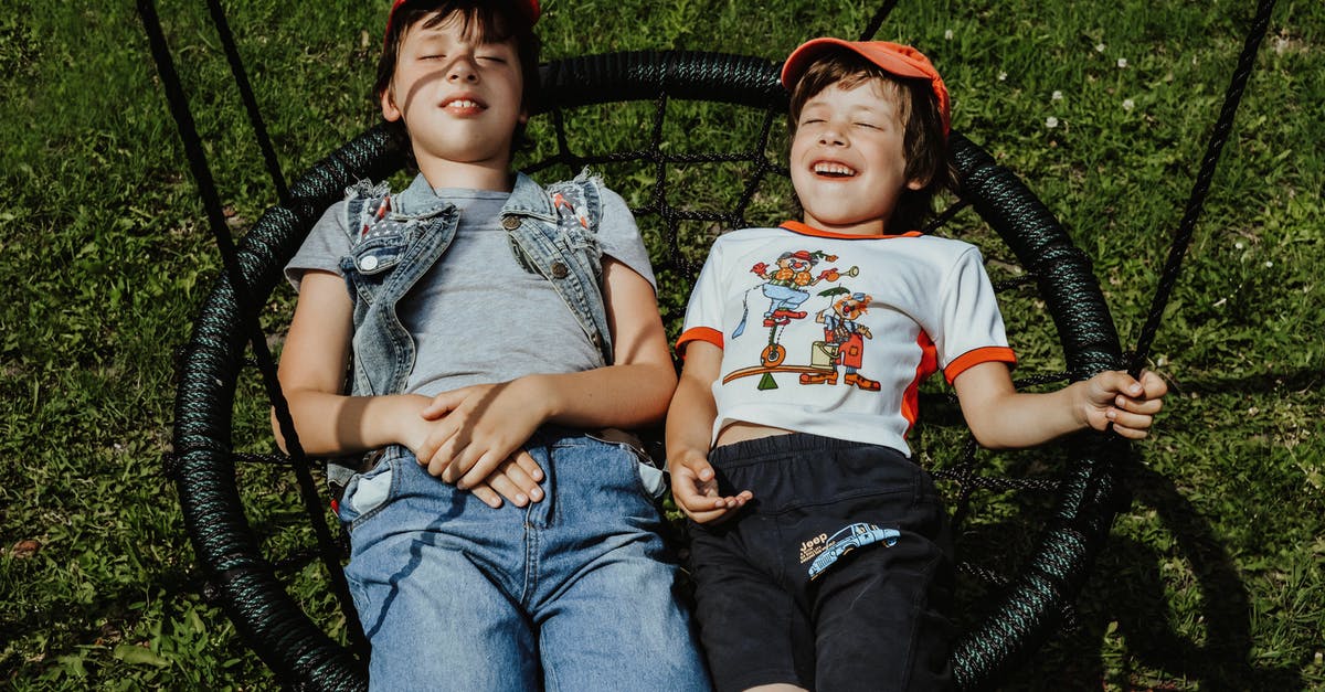 Buckwheat groats have grassy smell? - From above of happy boys with closed eyes wearing caps lying on round swing on grassy lawn while having fun in yard Buckwheat groats have grassy smell? - From above of happy boys with closed eyes wearing caps lying on round swing on grassy lawn while having fun in yard