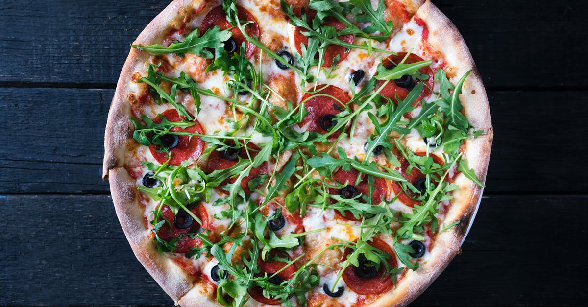 Burger/Kraft Slice Style Cheese - Tasty pizza with arugula leaves on dark background Burger/Kraft Slice Style Cheese - Tasty pizza with arugula leaves on dark background