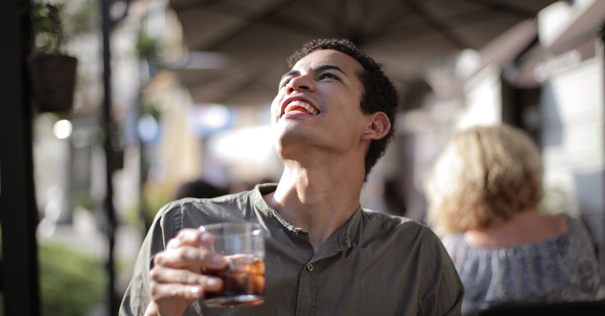 By what method, other than heat, can I cause the alcohol in a liquid to evaporate? - From below joyful young African American male with open mouth in casual clothes looking up while having refreshment with cool tasty beverage on cafe terrace
