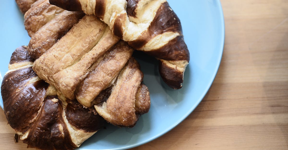 Cake with an impenetrable crust? - Top view of delicious crusty croissants with chocolate topping on wooden table in bakery Cake with an impenetrable crust? - Top view of delicious crusty croissants with chocolate topping on wooden table in bakery