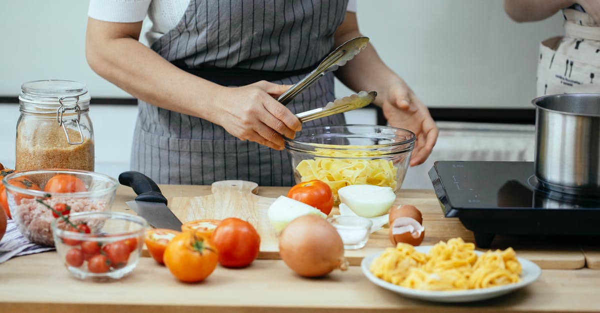 Can cheesecake be cooked without a spring-form pan? - Faceless women in aprons cooking delicious pasta with fresh tomatoes standing at counter in modern kitchen Can cheesecake be cooked without a spring-form pan? - Faceless women in aprons cooking delicious pasta with fresh tomatoes standing at counter in modern kitchen