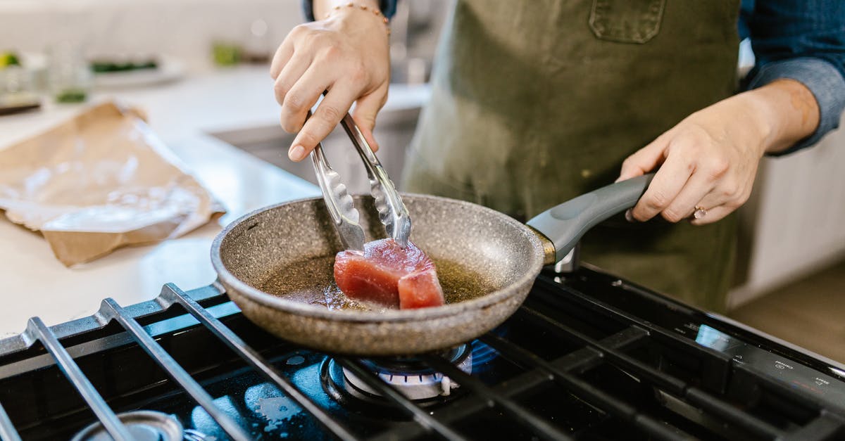 Can deep frying oil be too hot? - Female Hands Holding Frying Pan and Putting Chunk of Meat in Hot Frying Oil Can deep frying oil be too hot? - Female Hands Holding Frying Pan and Putting Chunk of Meat in Hot Frying Oil