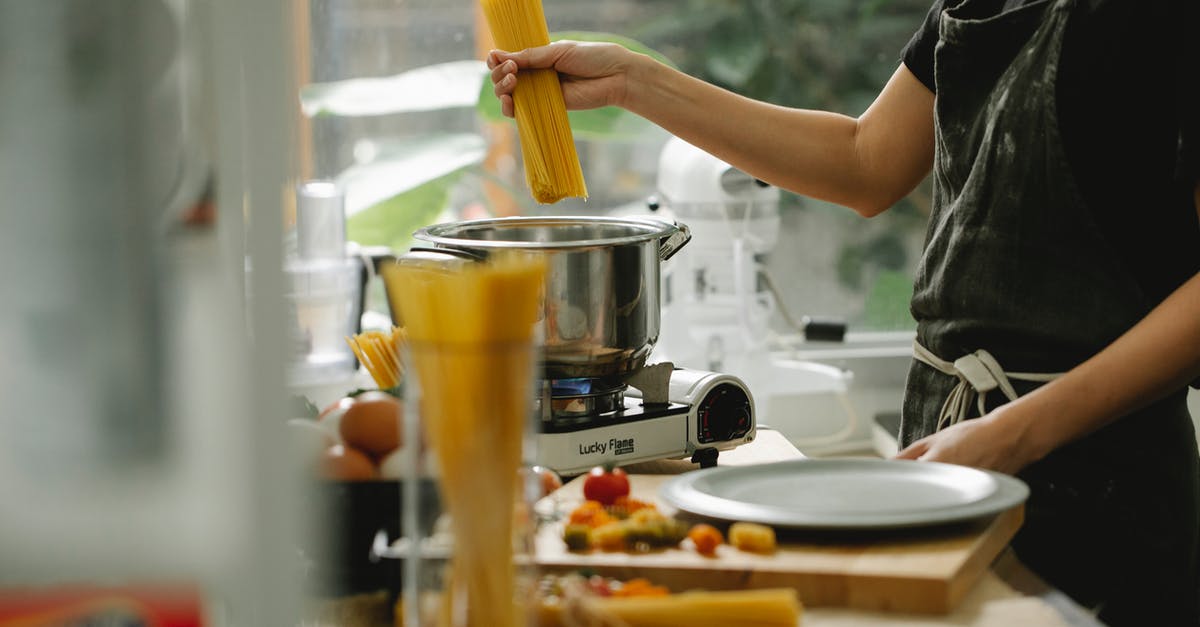 Can I add uncooked noodles directly to soup? - Crop anonymous female chef in apron putting spaghetti into pan with boiling water while cooking pasta in modern kitchen Can I add uncooked noodles directly to soup? - Crop anonymous female chef in apron putting spaghetti into pan with boiling water while cooking pasta in modern kitchen