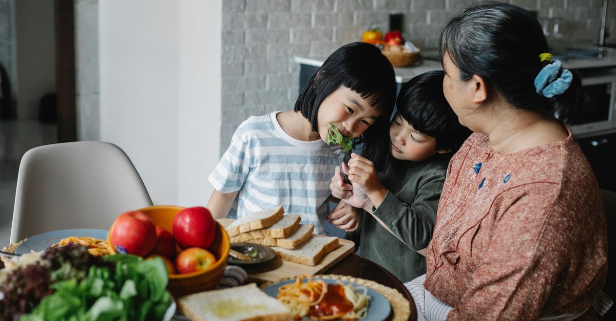 Can I find out the caloric content of bread by dehydrating it? - Cheerful little Asian siblings feeding each other while having lunch together with happy grandmother in modern kitchen Can I find out the caloric content of bread by dehydrating it? - Cheerful little Asian siblings feeding each other while having lunch together with happy grandmother in modern kitchen