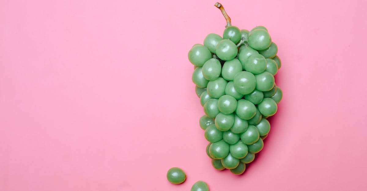 Can I make grapes honey from grape juice only - Ripe fresh green grapes on pink surface Can I make grapes honey from grape juice only - Ripe fresh green grapes on pink surface