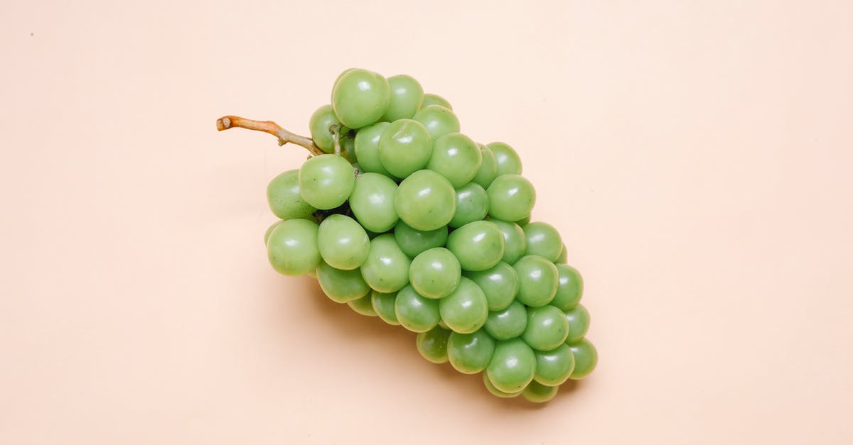 Can I make grapes honey from grape juice only - Top view of bunch of fresh delicious green grapes lying on beige surface Can I make grapes honey from grape juice only - Top view of bunch of fresh delicious green grapes lying on beige surface